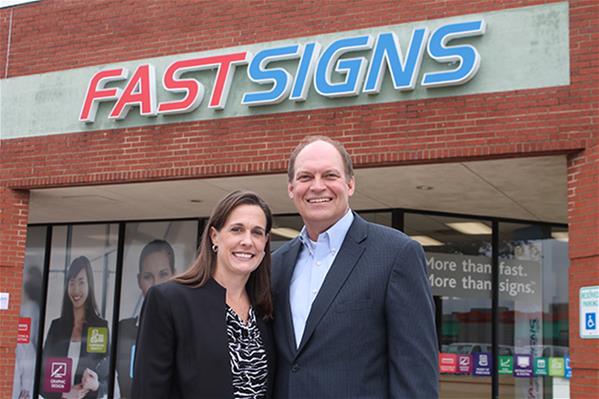 Mark and Shawn Glenn stand outside one of their FASTSIGNS store fronts